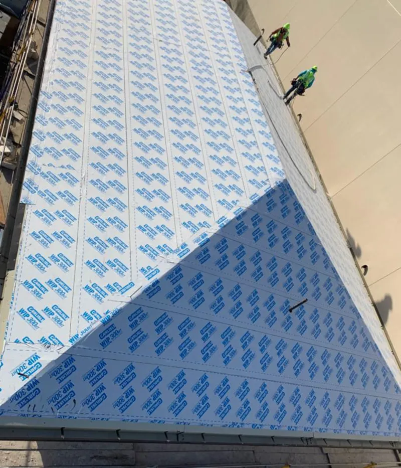 Professional roofers installing underlayment on a metal roof in Earlimart